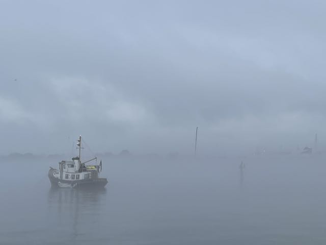 tugboat at anchor in fog